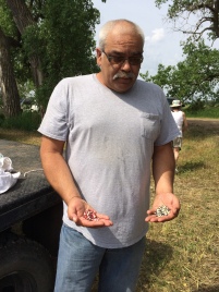 Amos Hinton, director of the Ponca Tribe's Agricultural Program, holding Ponca gray and red corn seed