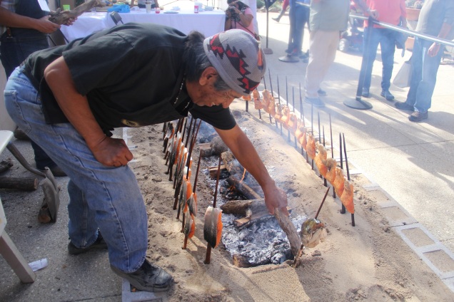 Ed Mata, roasting salmon over the fire. Photo by Elizabeth Hoover
