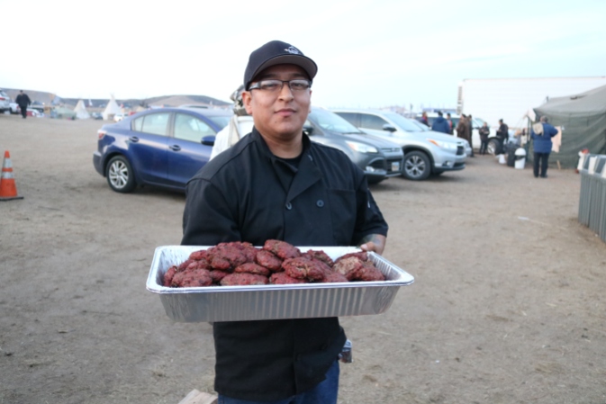 Chef Brian Yazzie with smoked buffalo burgers. Photo by Elizabeth Hoover